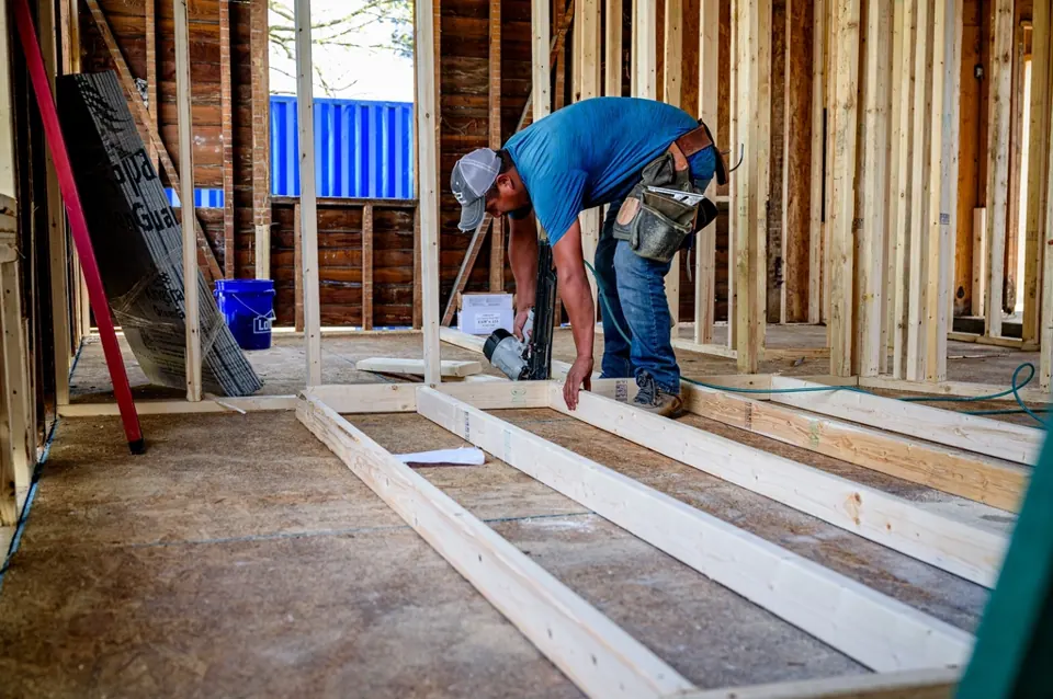 Builder nailing a timber wall frame together on site